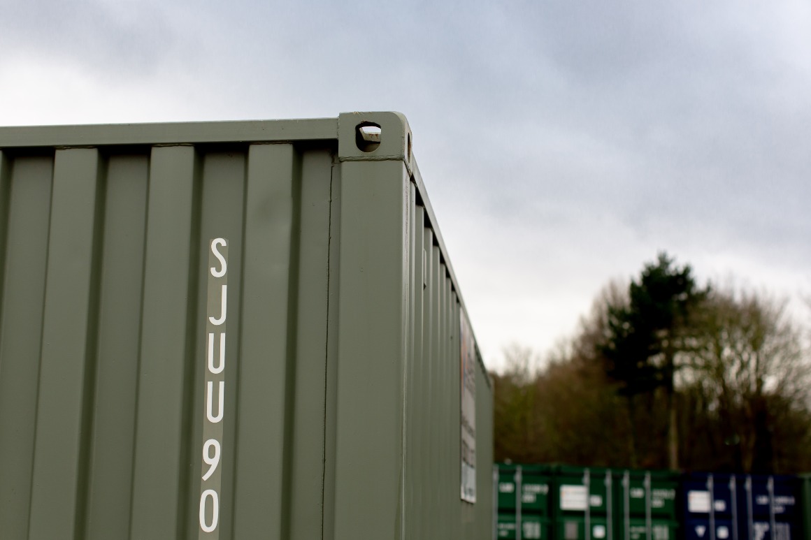 Green container corner with tree in background