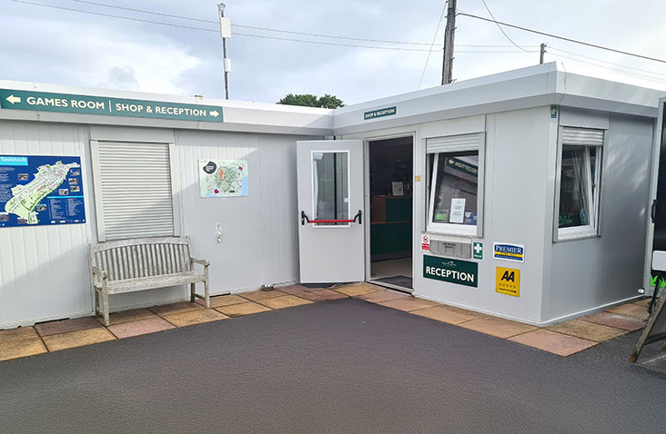 Modular reception unit with signage, shop entrance and customer service area for visitor management at commercial or leisure sites.