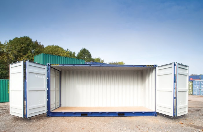     Blue 40ft high cube side opening shipping container with both side doors fully open, revealing the spacious interior and wooden flooring, positioned on a gravel surface in a storage yard with other containers nearby. 