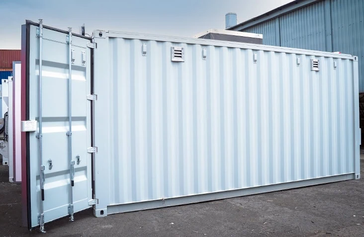 Battery storage and testing container with open cargo door, showing a modified white shipping container with ventilation louvres and reinforced structure designed for safe battery testing.